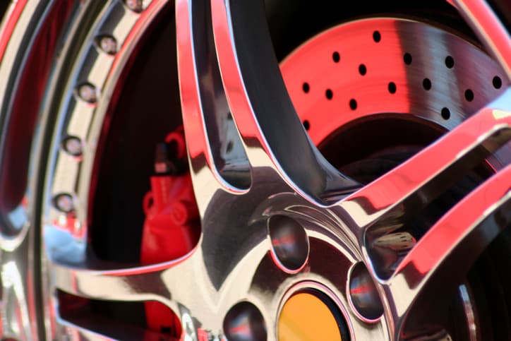 Close-up image of a red and chrome wheel, emphasizing its sleek design and reflective chrome accents.