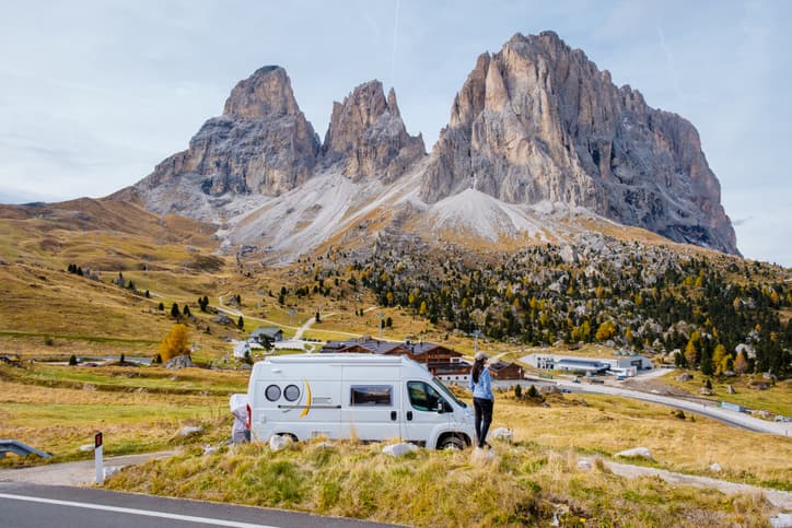 A scenic view of a camper van parked with a stunning mountain backdrop, highlighting nature's beauty.