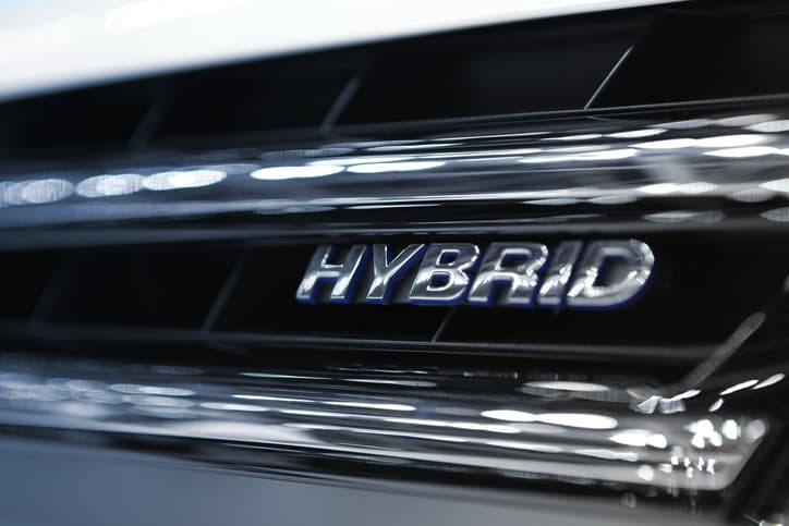 Hybrid car logo showcased on the front of a vehicle, representing innovation in sustainable transportation.
